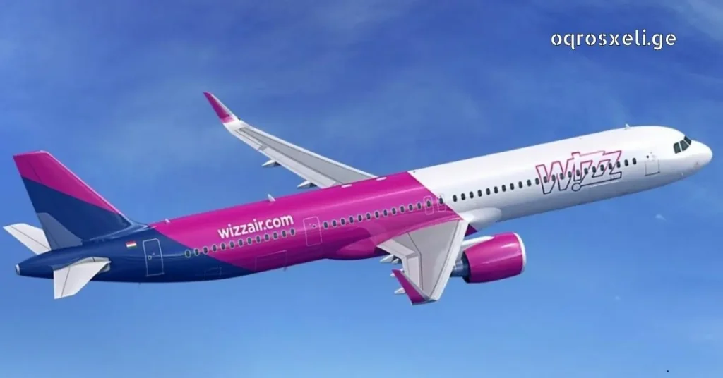 Side profile of a Wizz Air Airbus plane in flight against a bright blue sky with light clouds, showing the distinctive purple and pink livery and logo.