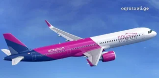 Side profile of a Wizz Air Airbus plane in flight against a bright blue sky with light clouds, showing the distinctive purple and pink livery and logo.